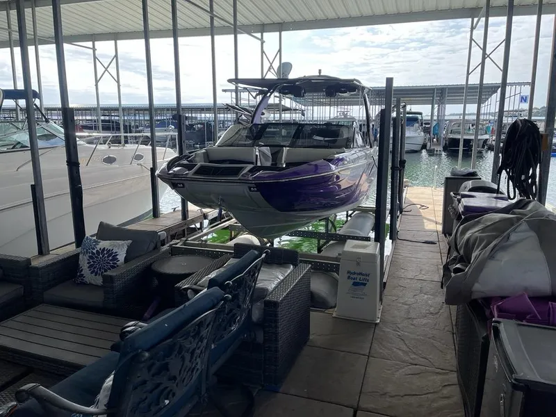 Slide: The Image of 2019 Centurion Fi25 boat docked in a marina with covered seating area. - 4