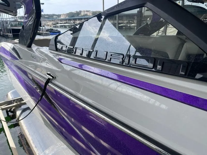 Slide: The Image of 2019 Centurion Fi25 boat with sleek purple and gray design docked at marina. - 7