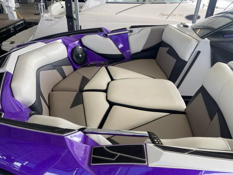 Slide: The Image of 2019 Centurion Fi25 boat interior with purple and white seating, featuring modern design and cup holders. - 8