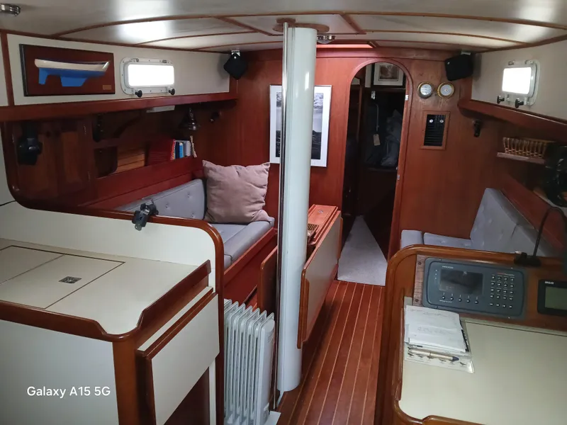 Slide: The Image of Interior of a 1992 Valiant 40 sailboat, featuring wood paneling and cozy seating. - 17