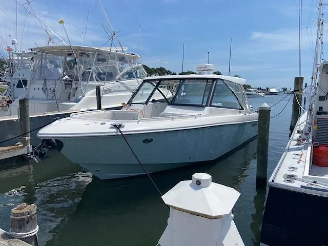 Slide: The Image of 2019 Everglades 340 Dual Console boat docked in a marina. - 2