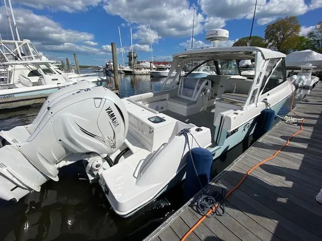 Slide: The Image of 2019 Everglades 340 Dual Console boat docked, featuring Yamaha engines, under a partly cloudy sky. - 3
