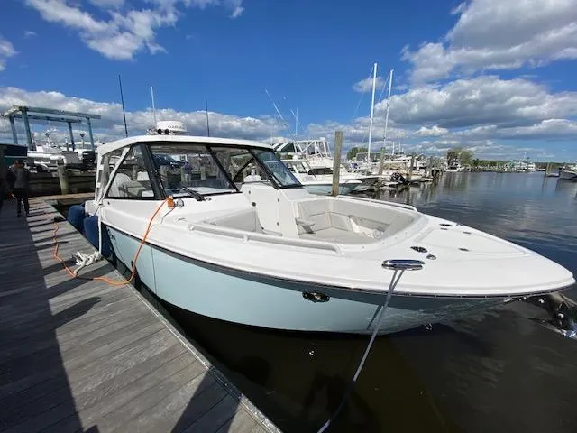 Slide: The Image of 2019 Everglades 340 Dual Console boat docked at marina under blue sky. - 4