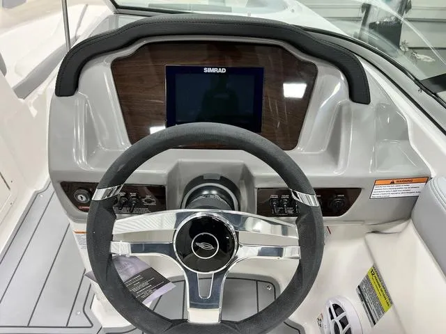 Slide: The Image of 2024 Chaparral 21 SSi boat dashboard with steering wheel and Simrad display. - 12