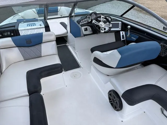 Slide: The Image of 2013 MasterCraft X45 boat interior with blue and white seating, modern dashboard, and steering wheel. - 10