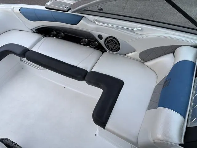 Slide: The Image of 2013 MasterCraft X45 boat interior with white and blue seating, cup holders, and speaker. - 11