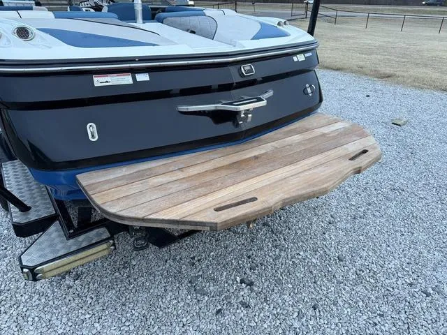 Slide: The Image of 2013 MasterCraft X45 boat with wooden swim platform on gravel surface. - 6