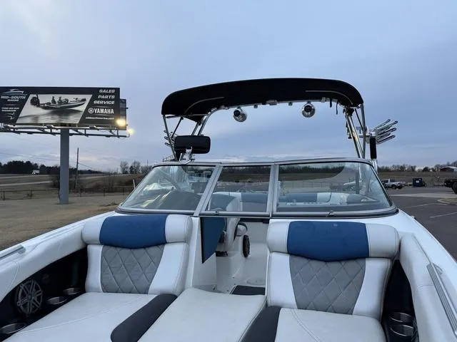 Slide: The Image of 2013 MasterCraft X45 boat interior with blue and white seating, under a cloudy sky. - 9