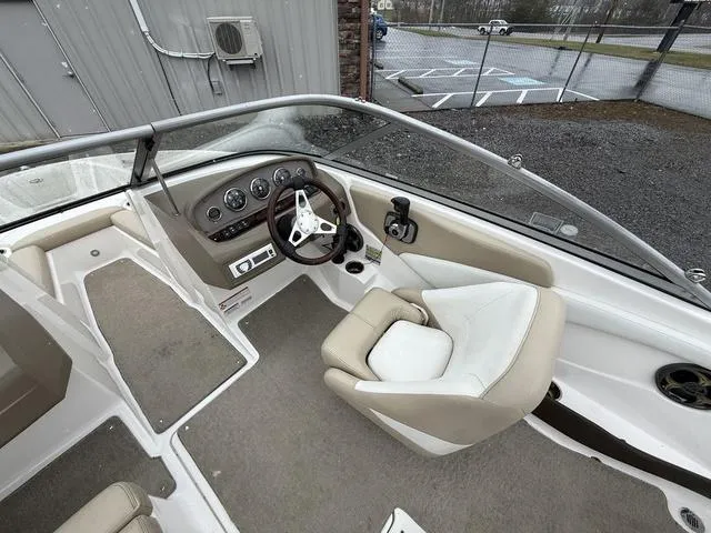 Slide: The Image of Interior of a 2014 Regal 1900 ES boat, featuring steering wheel and seating. - 10