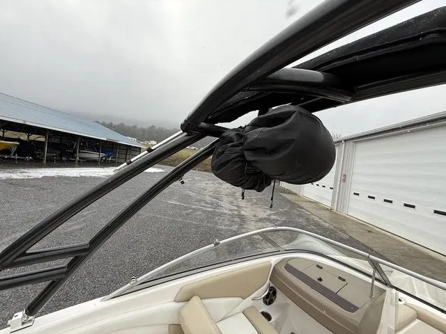 Slide: The Image of 2014 Regal 1900 ES boat with covered equipment on a rainy day. - 12