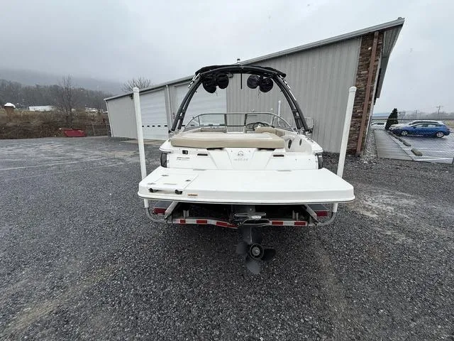 Slide: The Image of 2014 Regal 1900 ES boat, rear view, parked on gravel near a building. - 7