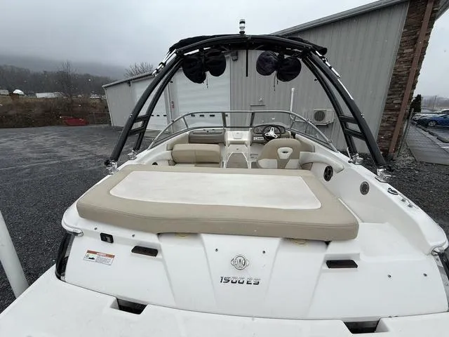 Slide: The Image of 2014 Regal 1900 ES boat with beige seating, parked outdoors near a building. - 8