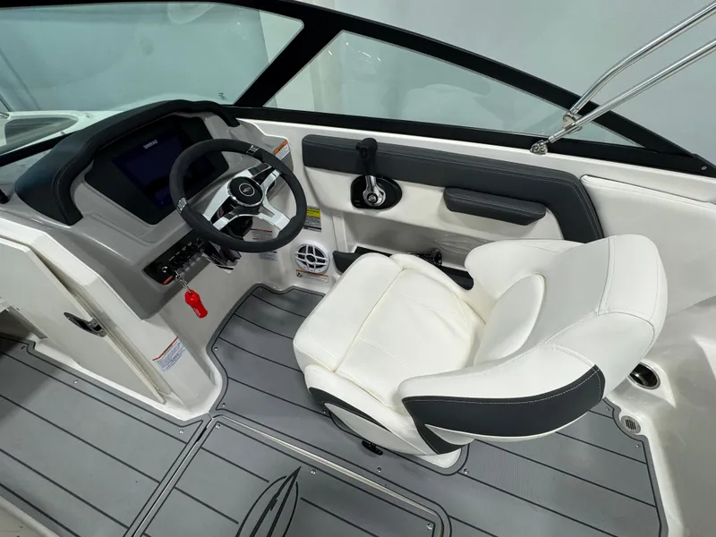 Slide: The Image of 2025 Chaparral 21 SSi Ski & Fish boat interior with steering wheel and white captain's chair. - 8