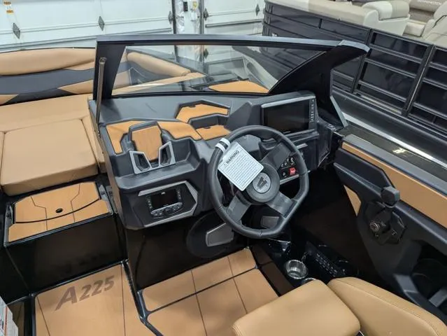 Slide: The Image of 2025 Axis Wake Research A225 boat interior with modern dashboard and tan seating. - 10