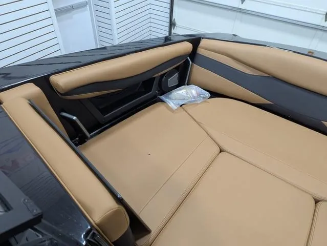 Slide: The Image of 2025 Axis Wake Research A225 boat interior with tan seating in a garage. - 11