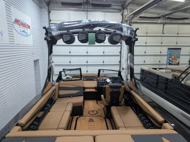 Slide: The Image of 2025 Axis Wake Research A225 boat interior with tan seating and advanced audio system. - 13
