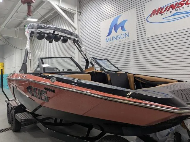 Slide: The Image of 2025 Axis Wake Research A225 boat in showroom, Munson Surf & Wake signage visible. - 2