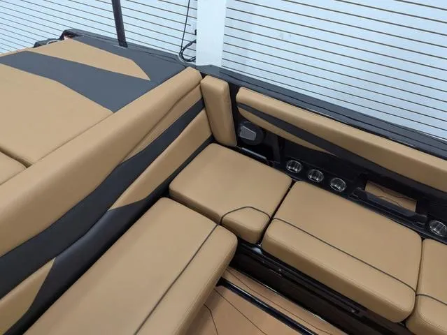 Slide: The Image of 2025 Axis Wake Research A225 boat interior with tan and black seating. - 7