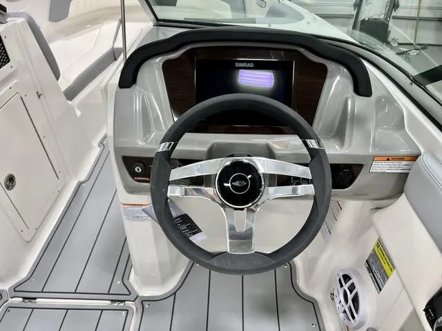 Slide: The Image of 2024 Chaparral 21 SSi boat dashboard with steering wheel and Simrad display. - 10