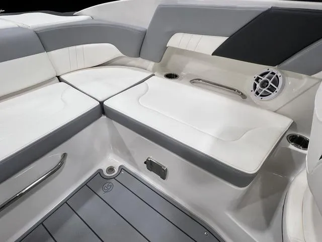 Slide: The Image of 2024 Chaparral 23 SSi boat interior with white and gray seating, speaker, and cup holders. - 11
