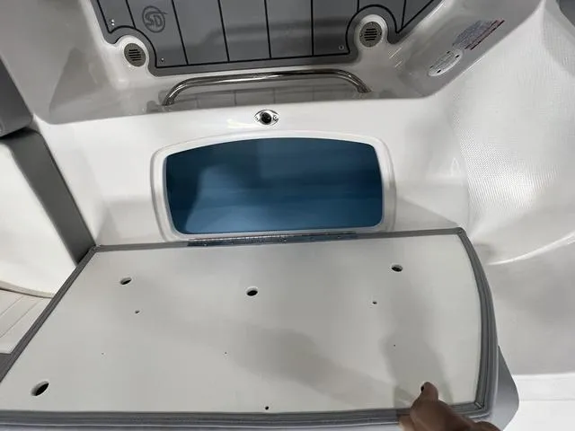 Slide: The Image of 2024 Chaparral 23 SSi boat storage compartment with open lid, showcasing interior space. - 13