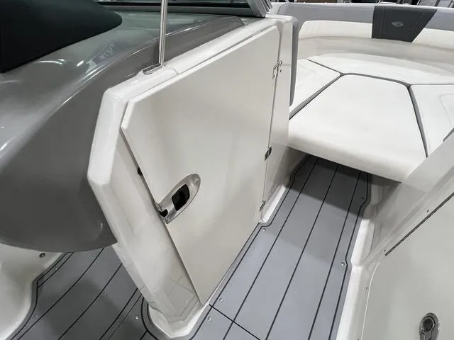Slide: The Image of 2024 Chaparral 23 SSi boat interior with open storage compartment and cushioned seating. - 20