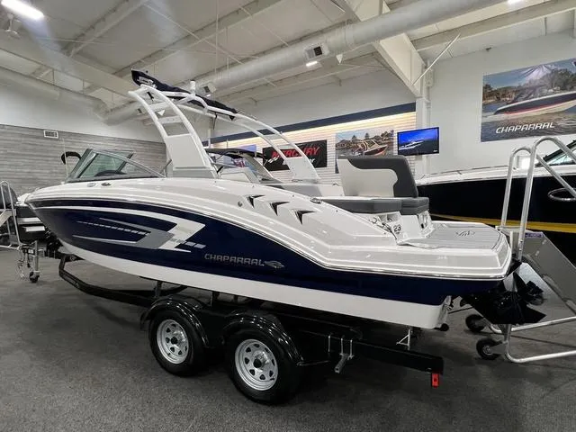 Slide: The Image of 2024 Chaparral 23 SSi boat on display in showroom, featuring sleek design and dual-axle trailer. - 3
