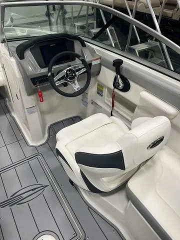 Slide: The Image of 2025 Chaparral 23 SSi boat interior with steering wheel and white seating. - 11