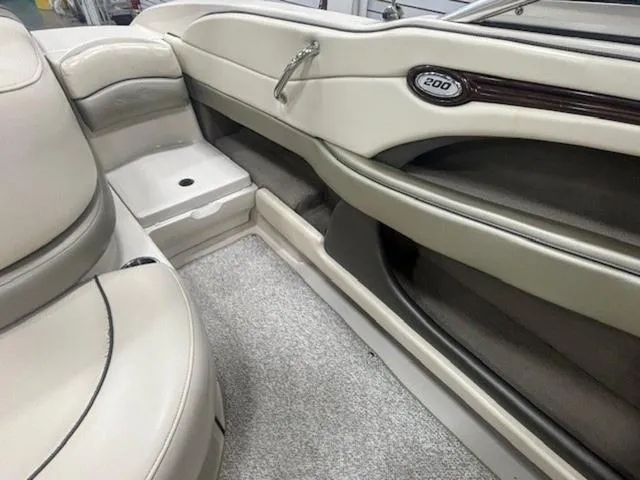Slide: The Image of Interior of a 2005 Sea Ray 200 Signature boat, featuring beige seating and carpet. - 17