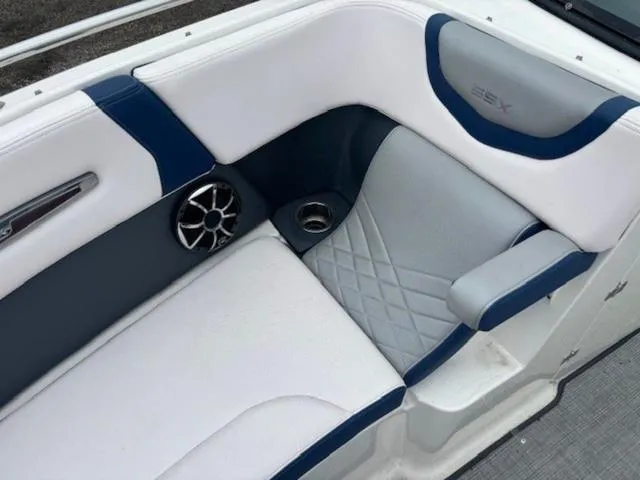 Slide: The Image of 2019 Chaparral 277 SSX boat interior with white and blue seating, speaker, and cup holder. - 18