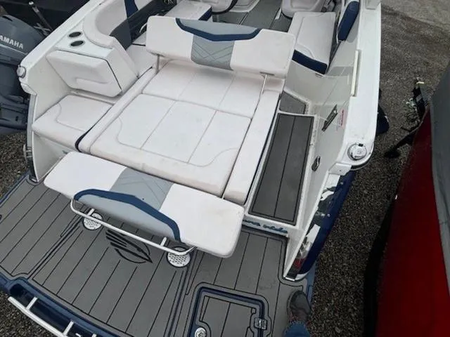 Slide: The Image of 2019 Chaparral 277 SSX boat interior with white and blue seating, gray flooring. - 19