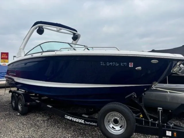 Slide: The Image of 2019 Chaparral 277 SSX boat on trailer, dark blue hull, parked outdoors. - 29
