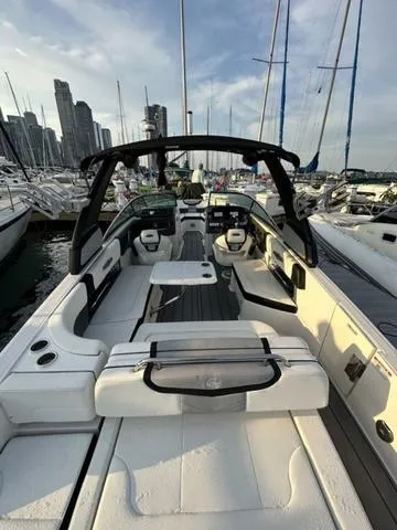 Slide: The Image of 2022 Chaparral 28 Surf boat docked in marina, city skyline in background. - 17