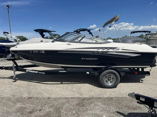 Slide: The Image of 2020 Stingray 208LR boat on trailer under clear blue sky. - 1