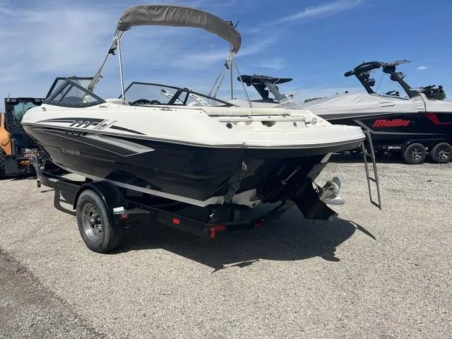 Slide: The Image of 2020 Stingray 208LR boat on trailer, parked outdoors under clear sky. - 2