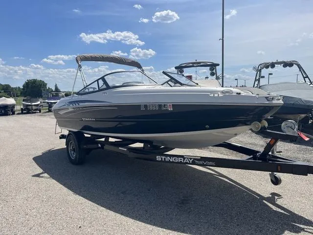 Slide: The Image of 2020 Stingray 208LR boat on trailer under clear blue sky. - 3