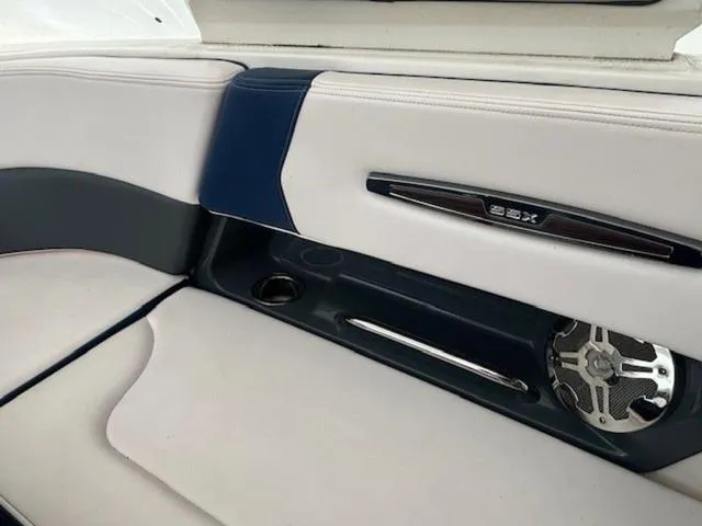 Slide: The Image of 2020 Chaparral 257 SSX boat interior with white and blue seating and speaker detail. - 10