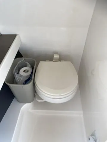 Slide: The Image of 2016 Sea Ray 280 SLX boat bathroom with toilet and storage bin. - 15