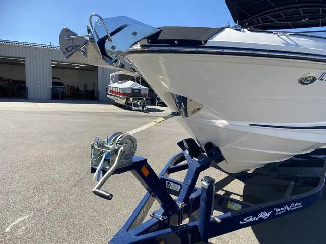 Slide: The Image of 2016 Sea Ray 280 SLX boat on trailer in sunny marina setting. - 7