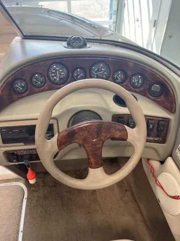 Slide: The Image of 1997 Chaparral 2130 SS boat dashboard with wood accents and steering wheel. - 23