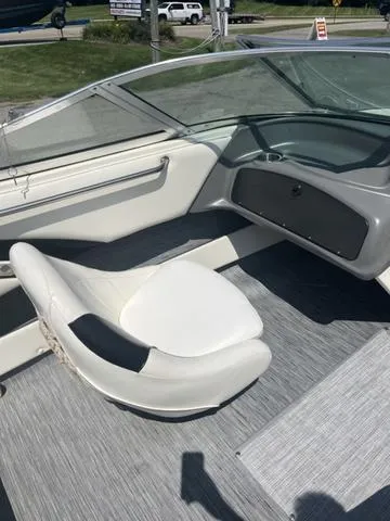 Slide: The Image of 1999 Rinker 212 Bowrider Captiva interior with white seating and gray flooring. - 7