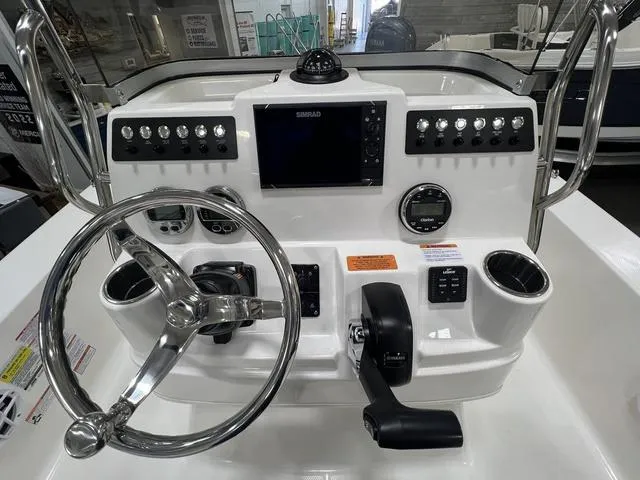 Slide: The Image of 2024 Robalo 206 Cayman boat dashboard with steering wheel and control panel. - 12