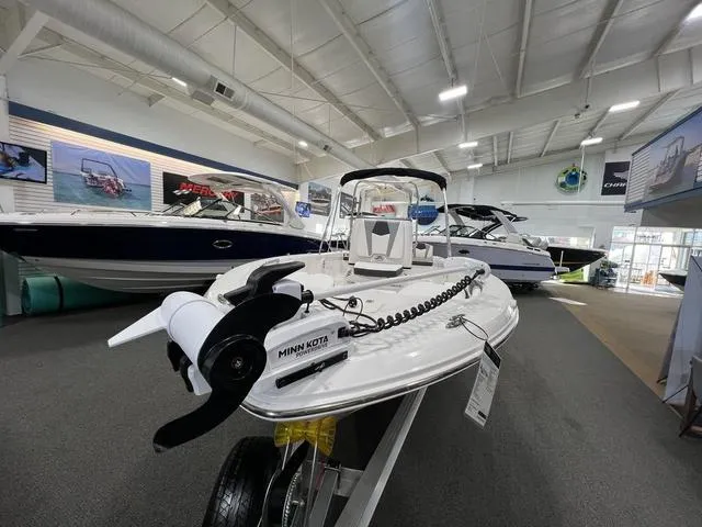 Slide: The Image of 2024 Robalo 206 Cayman boat displayed in a showroom with other boats. - 4