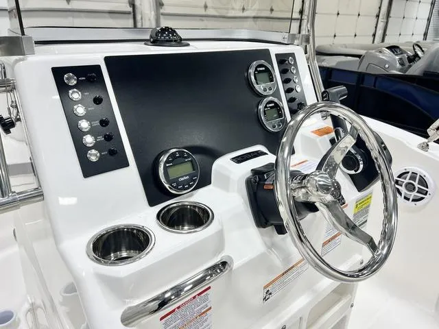 Slide: The Image of 2024 Robalo R180 boat dashboard with steering wheel, gauges, and controls. - 10
