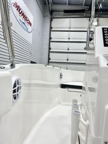 Slide: The Image of 2024 Robalo R180 boat interior in showroom, featuring sleek white design and modern controls. - 11