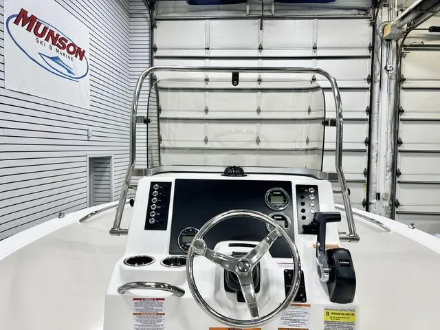 Slide: The Image of 2024 Robalo R180 boat dashboard with steering wheel and controls in showroom. - 9