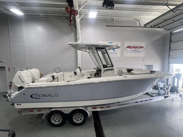 Slide: The Image of 2024 Robalo R250 boat on trailer in showroom, side view. - 1