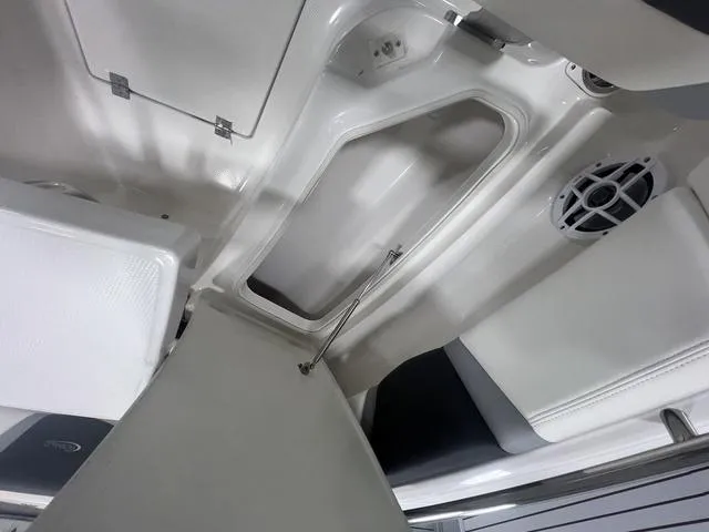 Slide: The Image of 2024 Robalo R250 boat interior storage compartment with speaker and white seating. - 35