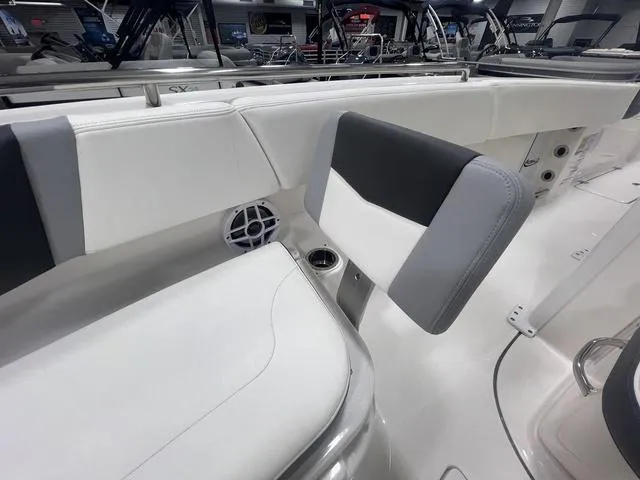 Slide: The Image of 2024 Robalo R250 boat interior with white and gray seating, speaker, and cup holder. - 38
