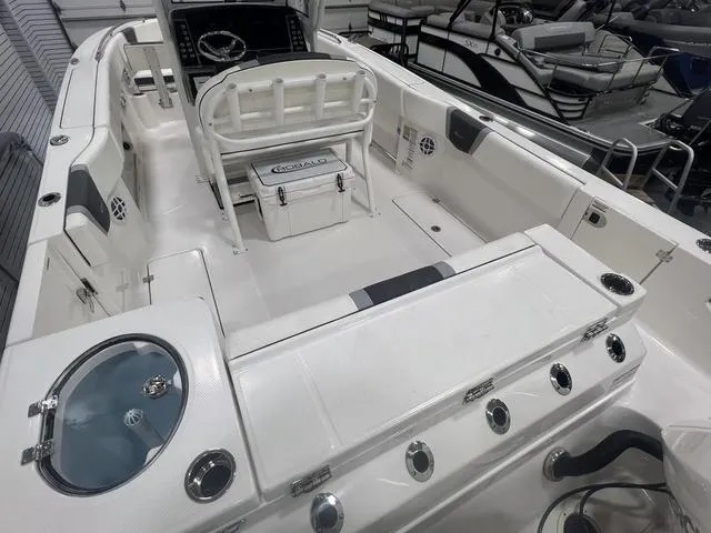Slide: The Image of 2024 Robalo R250 boat interior with seating, steering console, and storage compartments. - 7